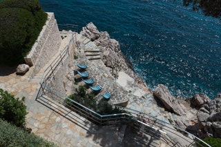 Image may contain Nature Outdoors Scenery Rock Handrail Sea Water Path Waterfront and Shoreline